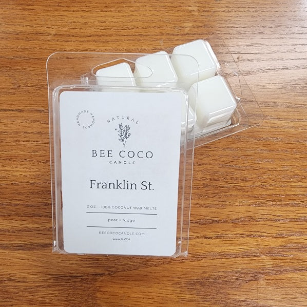 Packaged wax melts with 'Bee Coco' label on a wooden surface