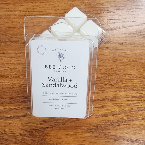 Bee Coco Vanilla + Sandalwood wax melts in clear packaging on a wooden surface
