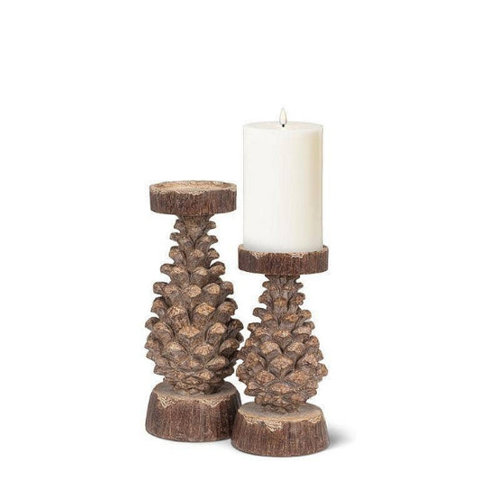 large and small pinecone pillar camdle holders showing a white pillar candle on a white background