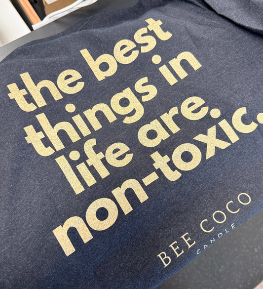 black t-shirt back. "the best things in life are non-toxic" slogan in gold