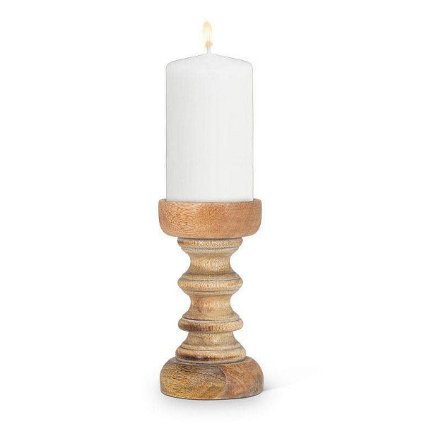 A turned pillar holder made of mango wood with a grey wash finish and a matte-black metal candle plate, displaying a white candle.