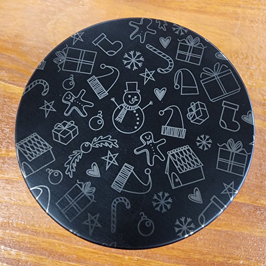 Laser engraved candle lid detail with cute winter-themed design on a wooden surface