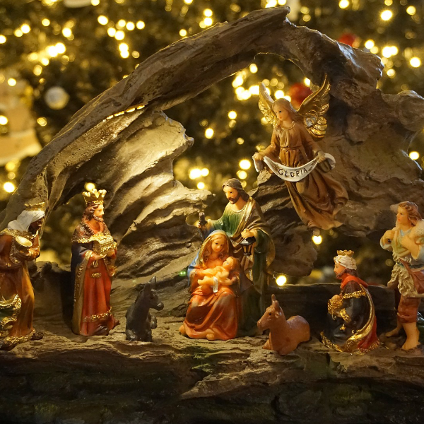 A Christmas-themed wax melt with a nativity scene featuring figures of Mary, Joseph, and baby Jesus, set against a backdrop of a tree decorated with lights.