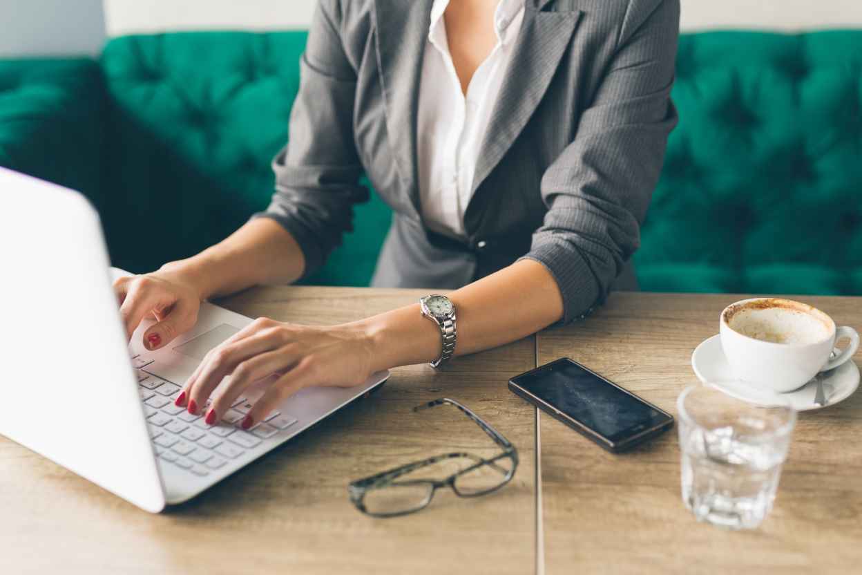 Woman on laptop leaving a review for the best gift shop in Geneva, Bee Coco Candle.