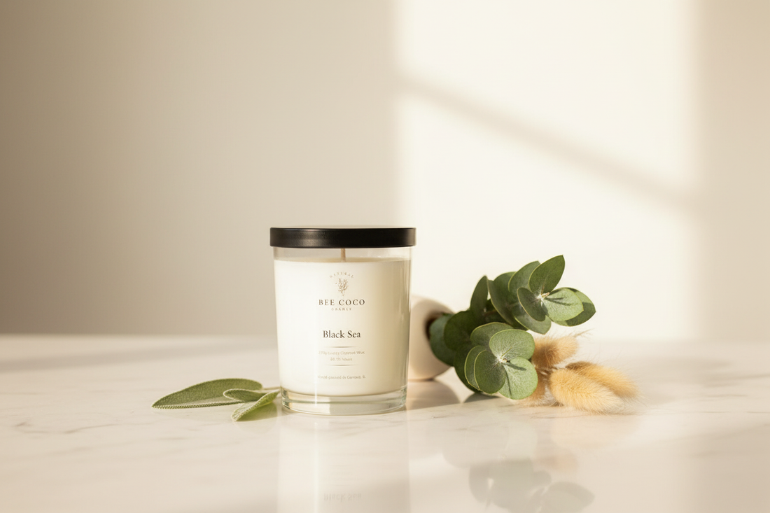 Bee Coco Candle Black Sea 13oz non-toxic coconut wax candle on a marble surface with soft warm lighting and fresh botanicals
