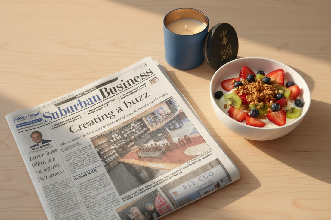 Bee Coco Candle featured in the Daily Herald Suburban Business section, 'Creating a Buzz,' displayed alongside a morning breakfast bowl on a light wood table.