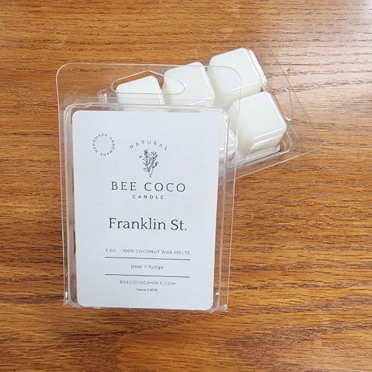 Packaged wax melts with 'Bee Coco' label on a wooden surface