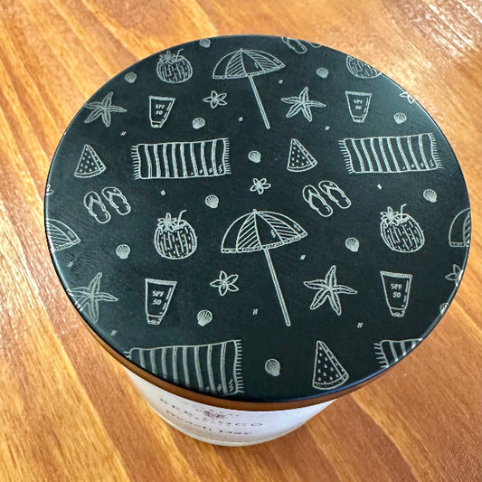 Black lid with white beach patterns on a wooden surface