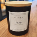 Fjord non-toxic luxury candle by Bee Coco Candle on a wooden surface with a blurred background