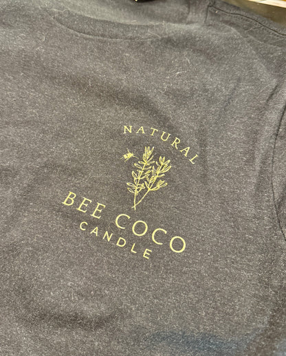 black tee with 'Bee Coco Candle' logo printed in gold on front chest pocket