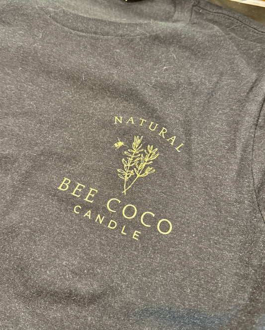 black tee with 'Bee Coco Candle' logo printed in gold on front chest pocket