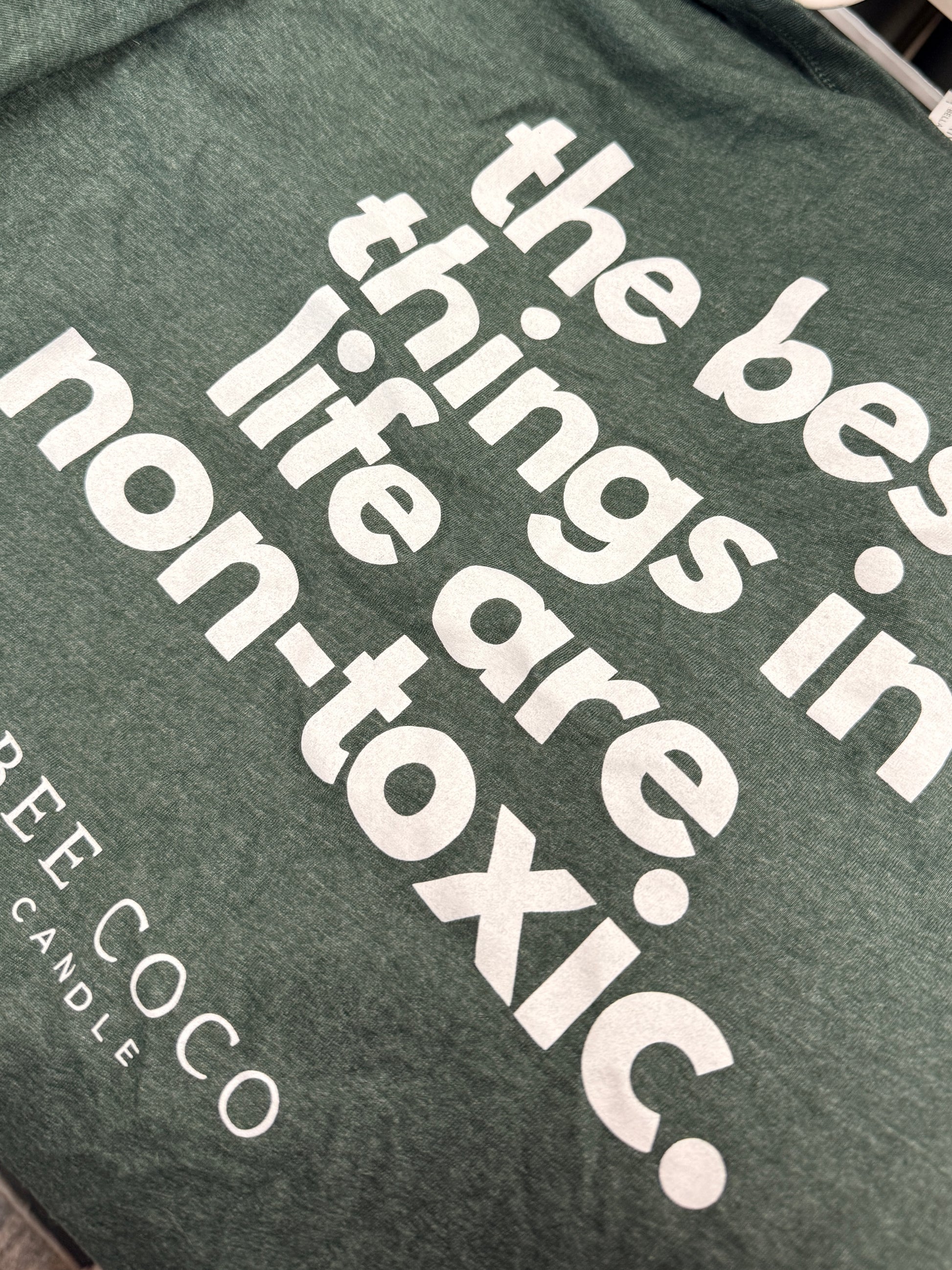 green t-shirt back. "the best things in life are non-toxic" slogan in white