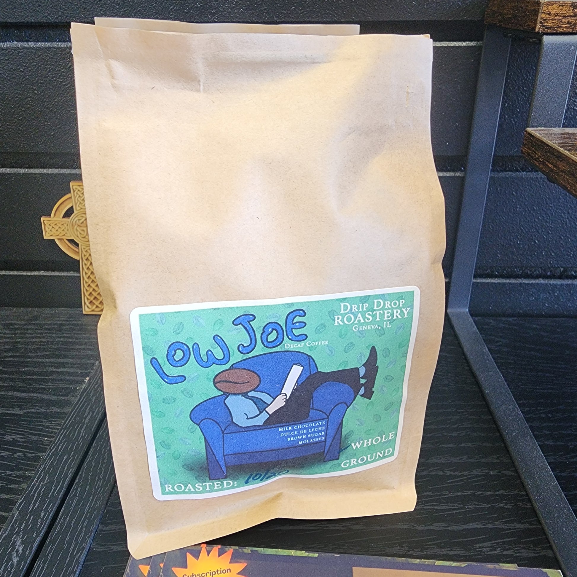 Coffee package with a label featuring a blue bear and text on a dark wooden surface.