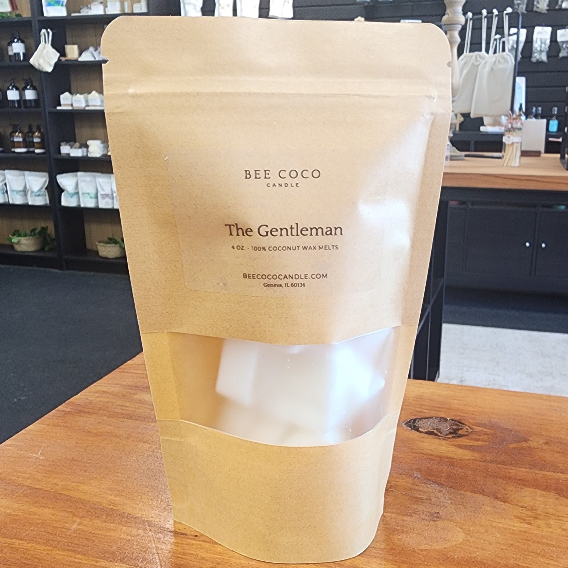 Product packaging labeled 'The Gentleman' on a wooden surface with a blurred background of shelves.