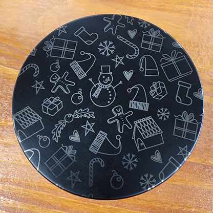 Laser engraved candle lid detail with cute winter-themed design on a wooden surface