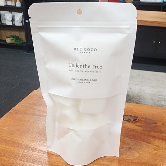 White packaging of 'Bee Coco' on a wooden table with a store interior in the background