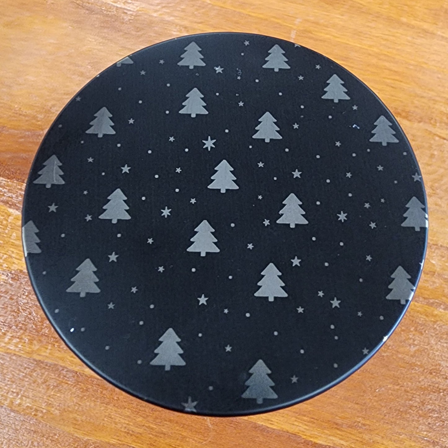 Laser engraved candle lid detail with cute tree theme.