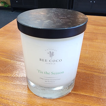 Candle with a black lid on a wooden surface